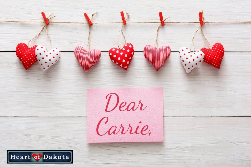 Heart of Dakota Dear Carrie post - Picture of red, white, and pink cloth hearts on a clothesline, against a white wood background. Beneath the hearts, a pink post it note pinned to the wood reads "Dear Carrie" in red, decorative handwriting