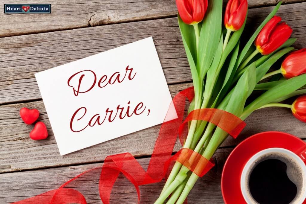 Heart of Dakota Dear Carrie - photo of red roses bound at the stem with red ribbon. The bunch of roses lays on a vintage wooden table beside a hot cup of coffee. To the left, a small stationary card reads "Dear Carrie" in decorative red script.