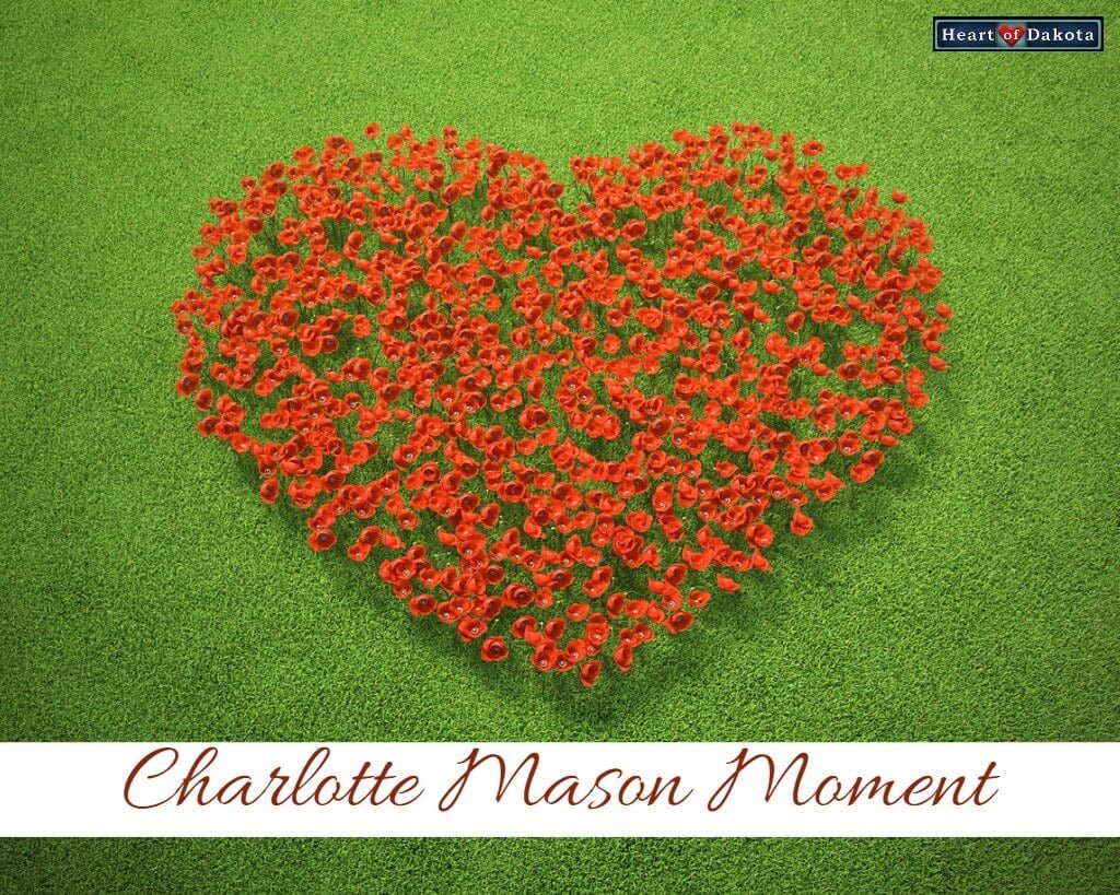 Heart-shaped bed of red roses on green grass. Text on the bottom reads: "Charlotte Mason Moment."